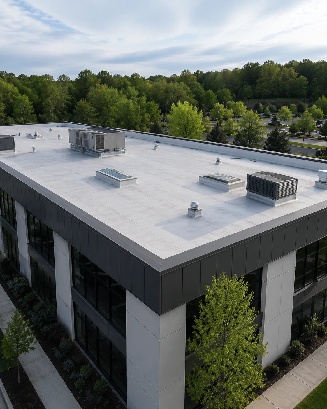 Aerial view of a finished white low-slope commercial roof with HVAC units and skylights.