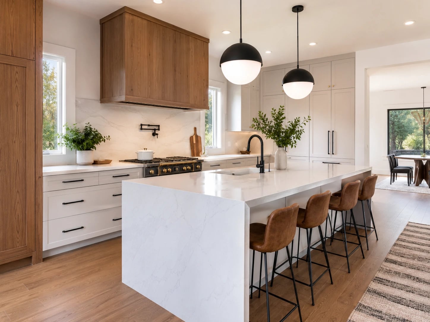 Contemporary residential kitchen with wood cabinetry, stone island and pendant lighting.