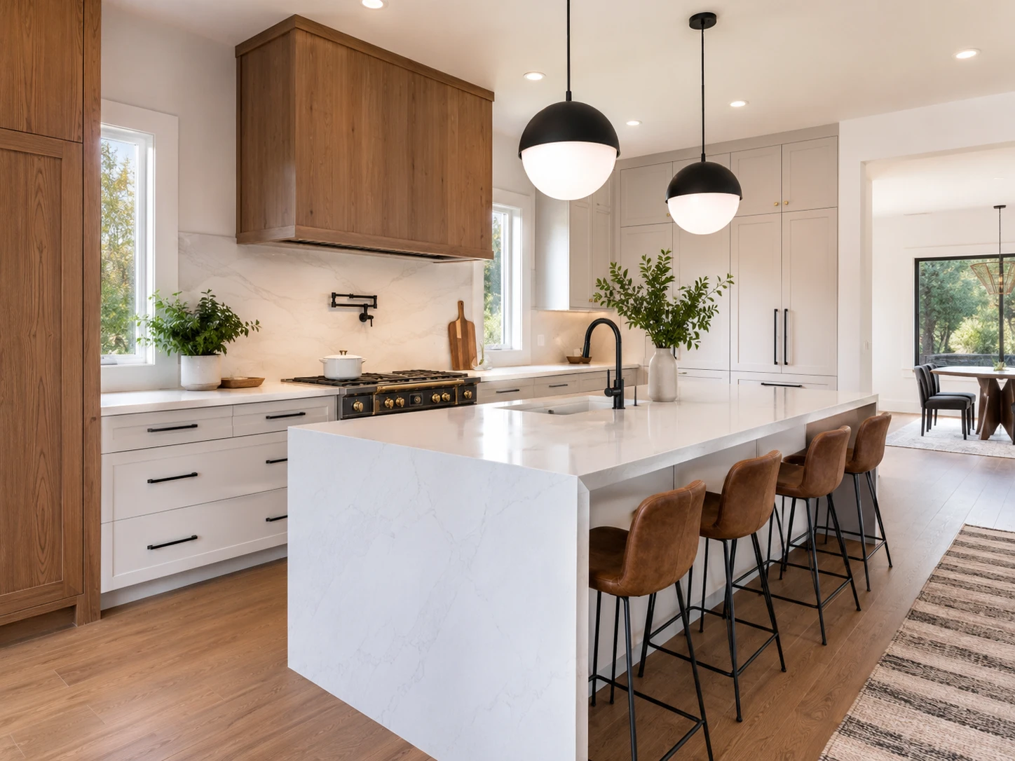 Contemporary residential kitchen with wood cabinetry, stone island and pendant lighting.